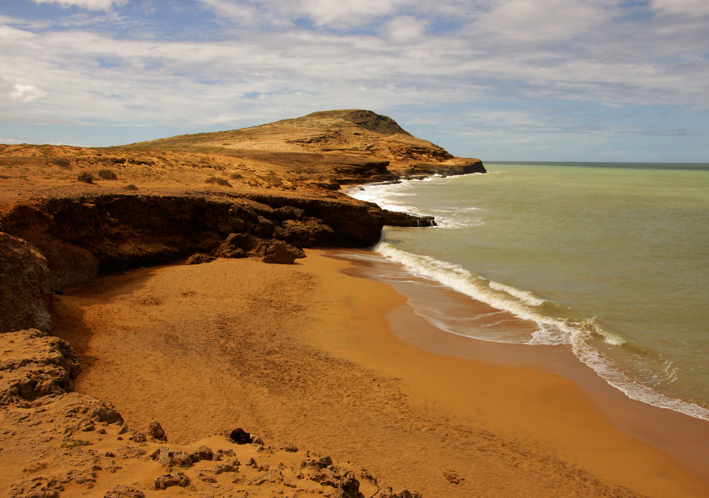 Cabo Vela beach wit
	h orange sand and blue sky